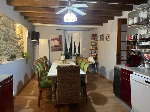une cuisine avec une table et des chaises ainsi qu'un ventilateur de plafond dans l'établissement Maison familiale Centre France, à Meunet-sur-Vatan