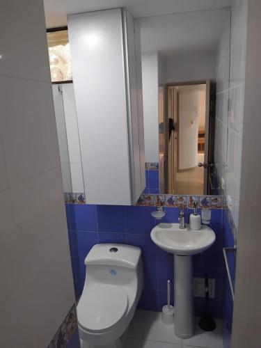 a bathroom with a white toilet and a sink at Beach front paradise Rodadero in Gaira