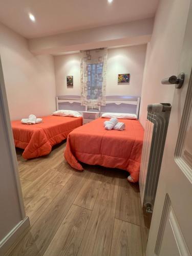 two beds with red sheets in a room at Garelly 2 in San Vicente de la Barquera
