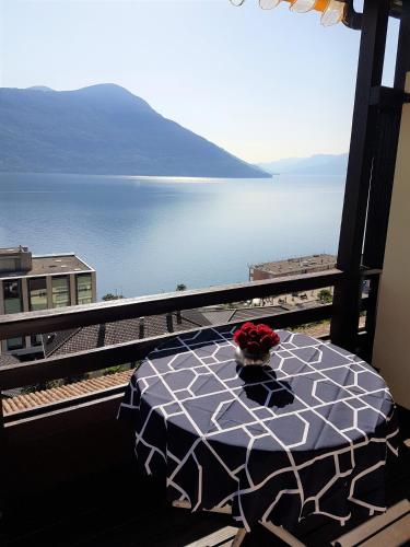 a table on a balcony with a view of the water at "Vista dolce" in Brissago