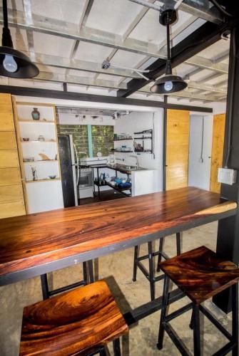 a large wooden table in a room with a kitchen at Casa Del Oeste, Playa Avellanas Beach House in Playa Avellana