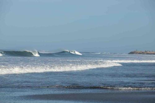 a wave in the ocean on a beach at Casa Del Oeste, Playa Avellanas Beach House in Playa Avellana