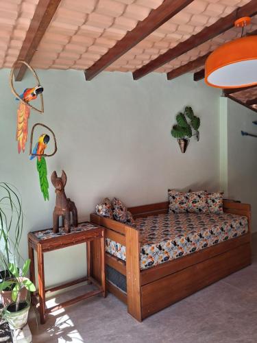 a bedroom with a wooden bed and a table at Casa da Farofa in Morro de São Paulo