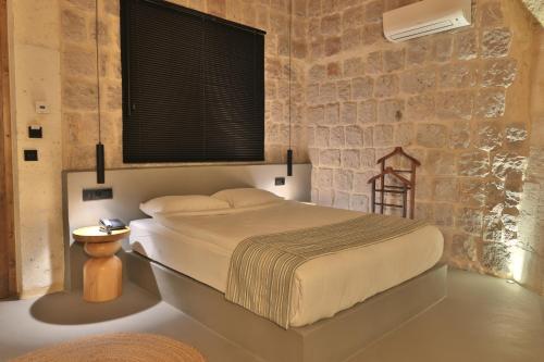 a bedroom with a bed and a brick wall at Simurg Cave House in Urgup