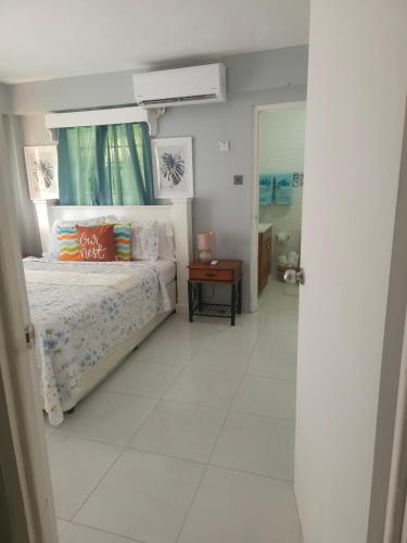 a bedroom with a bed and a window and a table at Sunny Acres Villa, St.Lucia in Choc