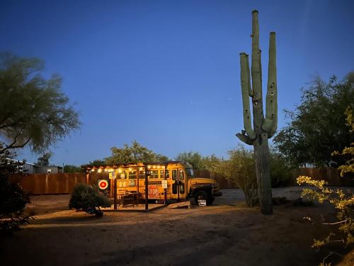 a yellow school bus parked in a dirt field at Tumbleweed charm of the Bus Stop Saloon in Cave Creek