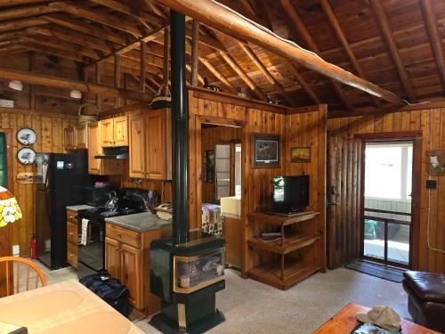 a kitchen with a stove in the middle of a room at Lake Access! Twin Birch Resort - The Brown Bear in Honor