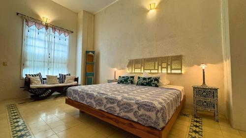 a bedroom with a bed and a couch in a room at Casa Zarah - Alma Hotels in Santa Marta