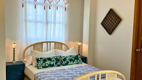 a bedroom with a bed with pillows and a window at Casa Zarah - Alma Hotels in Santa Marta
