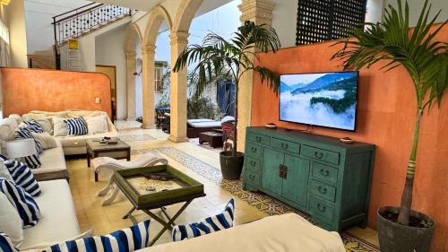 a living room with a television on a wall at Casa Zarah - Alma Hotels in Santa Marta