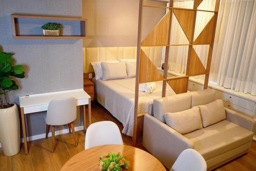 a small room with a bed and a table at Flat exclusivo conforto e estilo in Ribeirão Preto
