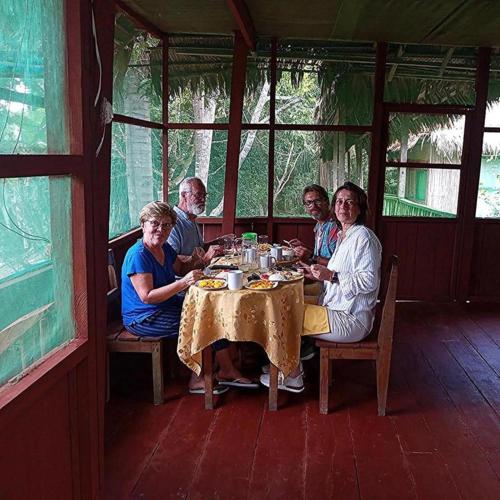 a group of people sitting at a table eating at Antares Jungle Lodge in Miraflores