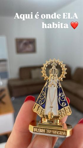 a person holding a gold and blue and white object at Casa em Aparecida 300m2 próximo ao Santuário Nacional in Aparecida