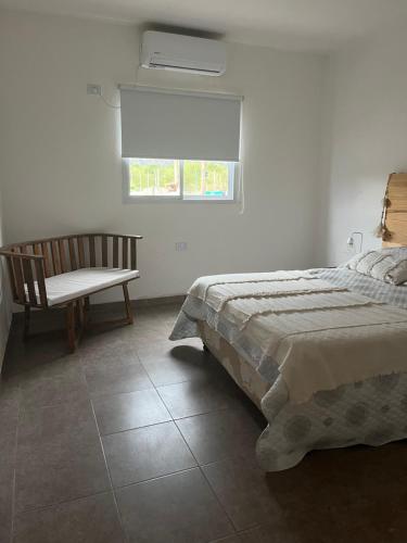 a bedroom with a bed and a chair and a window at Salir del Cráter Apart VALENTIN in Los Sarmientos