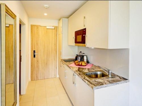 a kitchen with white cabinets and a sink at Apartment Sonnendeck in Ulstrupfeld