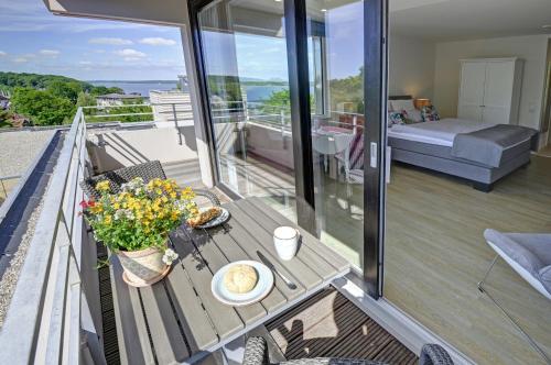 a balcony with a table with flowers and a bed at Apartment Sonnendeck in Ulstrupfeld