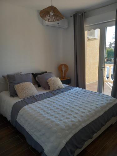 une chambre avec un grand lit avec une fenêtre dans l'établissement Appartement indépendant dans une villa, à Miramas