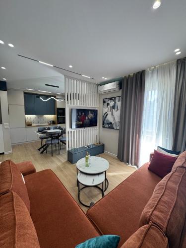 a living room with a couch and a table at Noir luxury apartment in Durrës