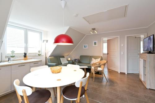 eine Küche und ein Wohnzimmer mit einem weißen Tisch und Stühlen in der Unterkunft Stieglitz Blick in Marienfelde