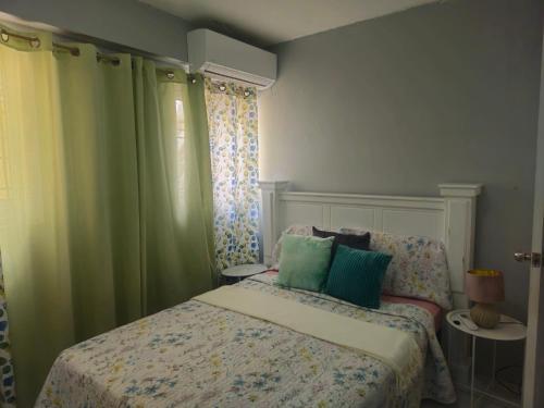 a bedroom with a bed with blue and green curtains at Sunny Acres Villa, St.Lucia in Choc