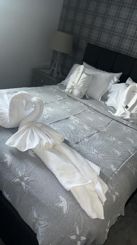 a bed with white sheets and a swan on it at Sleeps 7, entire apartment,with restaurant next door in Ebchester
