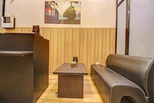 a room with a couch and a table next to a podium at Super Townhouse Kachnar House Vikas Nagar in Lucknow