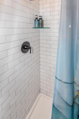 a bathroom with a shower with a blue shower curtain at Super Cute Five Bedroom Home in Denver Perfect For Girls Trips in Denver