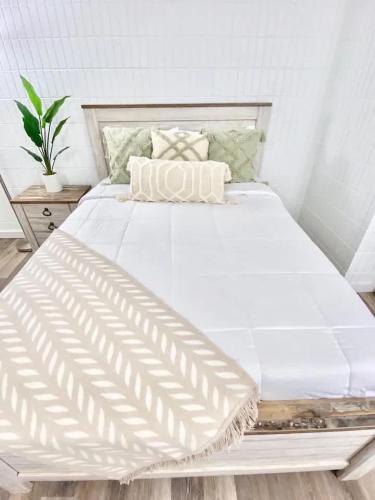 a large white bed in a white room at Luxury One-Bedroom Apartment with Ocean View in Hauula