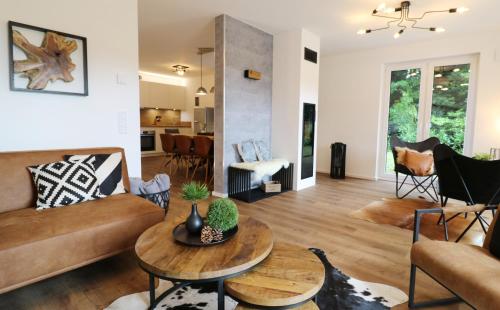 a living room with a couch and a table at Design-Ferienhaus "auf der Schanz" mit privater Sauna - Todtnau-Muggenbrunn, Feldberg im Schwarzwald in Muggenbrunn