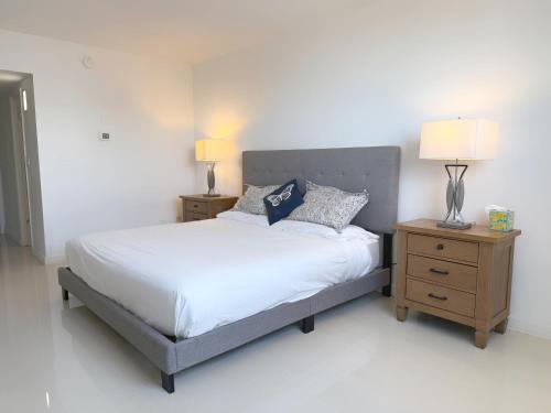 a bedroom with a bed with two nightstands and two lamps at 1 SPRING PROMO - Sunny Isles Seaview Condo, Walk to Beach, Amazing Amenities in Sunny Isles Beach