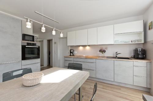 eine Küche mit weißen Schränken und einem Tisch mit Stühlen in der Unterkunft Girlitz Nest in Marienfelde