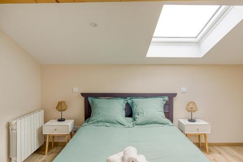 une chambre avec un grand lit avec une lucarne dans l'établissement Duplex du Cuchet Aux portes de la Gastronomie, à Chasselay
