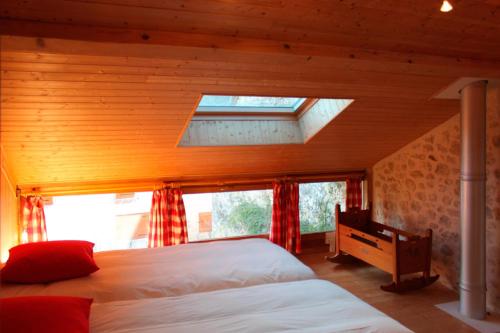 1 Schlafzimmer mit 2 Betten und einem Dachfenster in der Unterkunft VALRELEY, chambres et table d'hôtes eco-friendly avec bain nordique au sud du massif du Jura in Champagne-en-Valromey