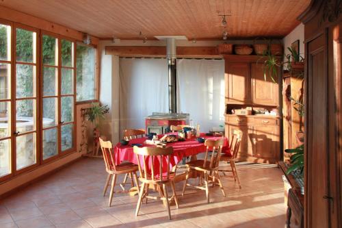 ein Esszimmer mit einem Tisch und Stühlen in einer Küche in der Unterkunft VALRELEY, chambres et table d'hôtes eco-friendly avec bain nordique au sud du massif du Jura in Champagne-en-Valromey