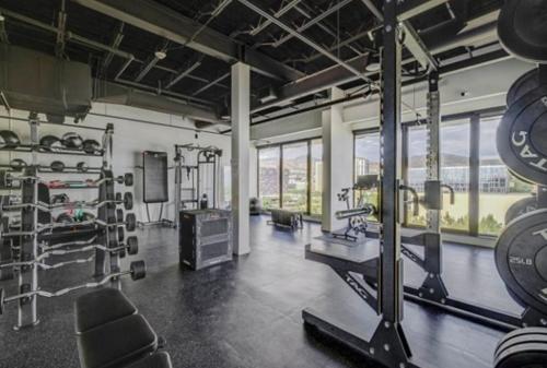 a gym with a large room with equipment and windows at Salt City Penthouse in Salt Lake City