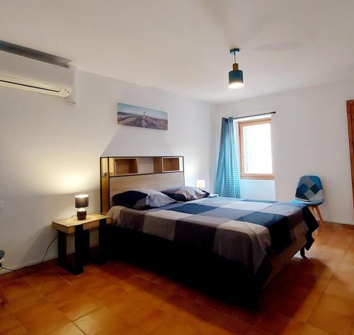 a bedroom with a large bed and a window at Chez ELLE in Oraison