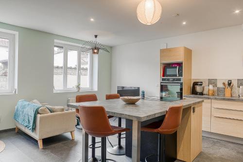 une cuisine avec une grande table et des chaises en bois dans l'établissement Duplex du Cuchet Aux portes de la Gastronomie, à Chasselay