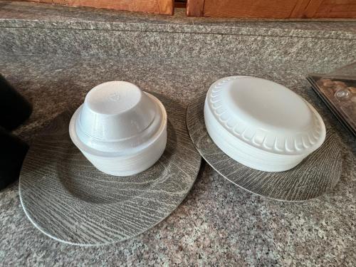 two white bowls sitting on a plate on a counter at labh inc Motel in Norfolk