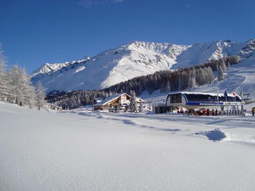 a ski lodge in the snow in front of a mountain at Hotel Tambò in Campodolcino