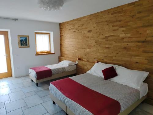 sypialnia z dwoma łóżkami i drewnianą ścianą w obiekcie Casa alla cascata w mieście Riva del Garda