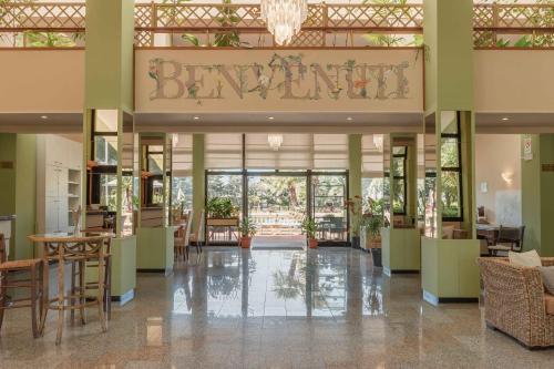 a lobby of a building with a restaurant at Hotel Riva Etrusca in Marina di Bibbona