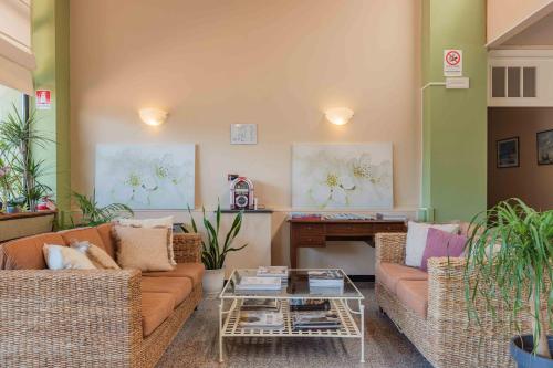 a living room with a couch and a piano at Hotel Riva Etrusca in Marina di Bibbona