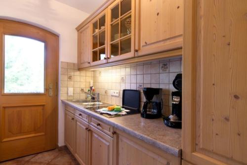 a kitchen with wooden cabinets and a counter top at Abendruh -566- in Krün