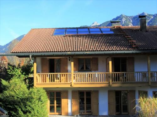 a house with a deck and solar panels on the roof at Abendruh -566- in Krün