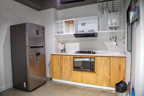 a kitchen with a stainless steel refrigerator and wooden cabinets at Edificio Helena in Medellín