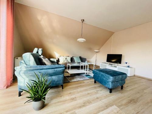 a living room with a blue couch and a tv at Fewo Elke in Barsinghausen
