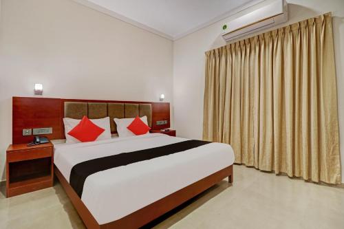 una camera da letto con un letto grande con cuscini rossi di Super Townhouse Kizhakkambalam Tourist Home a Cochin