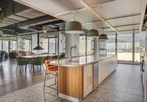 a kitchen with a counter and some chairs and tables at Salt City Retreat in Salt Lake City
