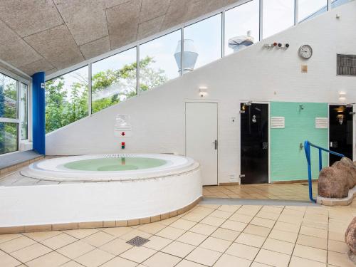 a large bathroom with a large circular tub in a building at 6 person holiday home on a holiday park in Hemmet in Hemmet