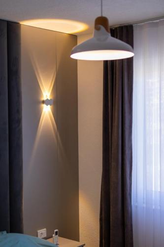 a bedroom with a mirror and a light on a wall at D & O Apartments in Mavrovo
